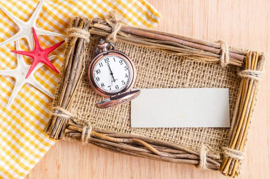 Blank paper tag for you text and vintage pocket watch on wooden background.