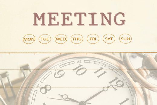 Close up meeting date on diary with pocket watch.
