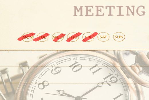 Close up meeting date on diary with pocket watch.