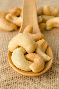 Roasted cashews on natural wooden background.