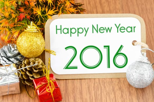 2016 on brown tag paper new year decoration on wooden background.