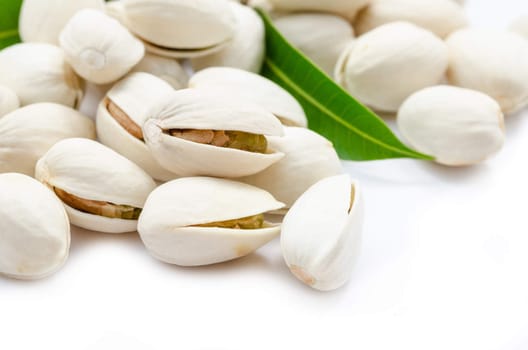 Tasty pistachio with leaves on a white background