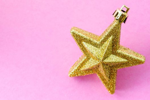 Golden Christmas star on pink background