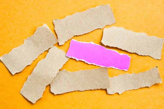 Piece of sheet blank pink and brown paper on a orange background