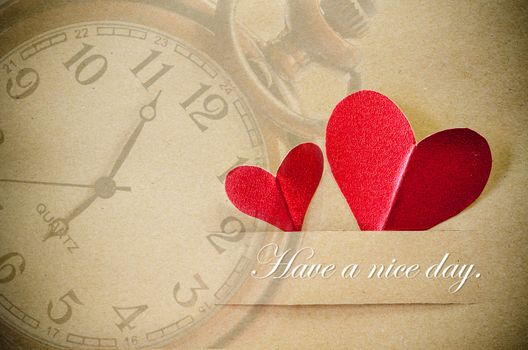 Have a nice day. Red heart on brown paper with clock background.