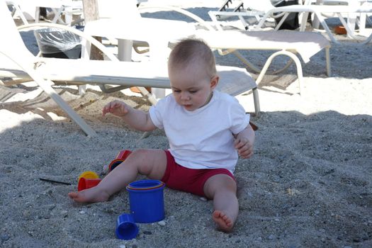 Baby girl playing on the beach sand