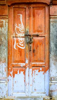 KATHMANDU, NEPAL - CIRCA NOVEMBER 2015: Vintage Coca-Cola advertisement painted on a wooden door.