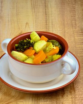 Vegetable Rustic Stew with Brussels Sprouts, Broccoli, Carrot, Potato and Leek in Bowl with closeup on Wooden background