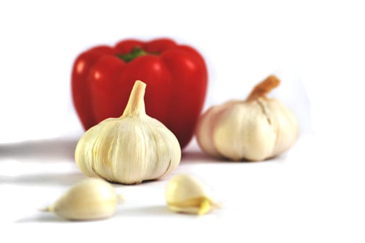 Garlic with paprika in the back, isolated on white background