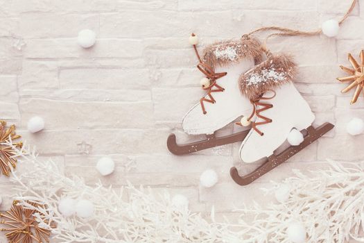 Figure skate Christmas ornament,  natural straw star ornaments and white pine twig on rustic background. Top view, blank space, vintage toned image