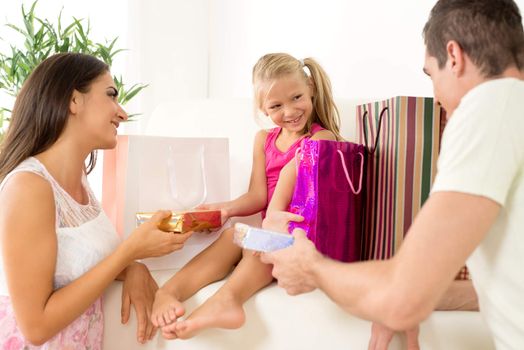 Beautiful young parents giving gift their cute little girl