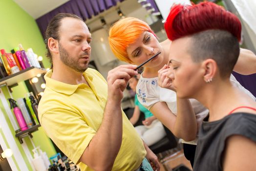 Makeup teacher helping students training to become makeup artist