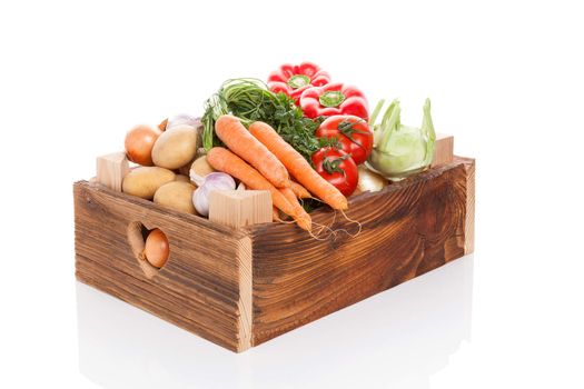 Organic seasonal vegetable in rustic wooden crate isolated on white background. Healthy vegetable eating. 