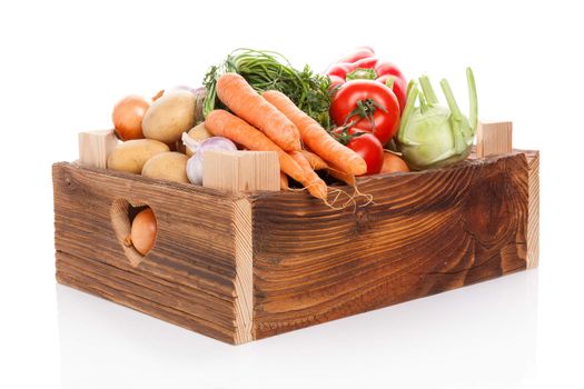 Organic seasonal vegetable in rustic wooden crate isolated on white background. Healthy vegetable eating. 