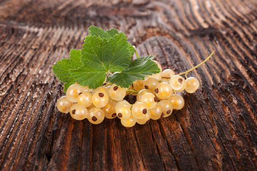 Delicious white currant on brown wooden rustic background. Healthy summer fruit eating. 