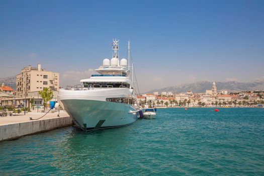 Large yacht at the pier on the background of the coastal town. Split, Croatia.