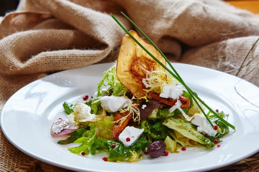 Fresh spring salad with feta cheese, red onion in white bowl. background with free text space.