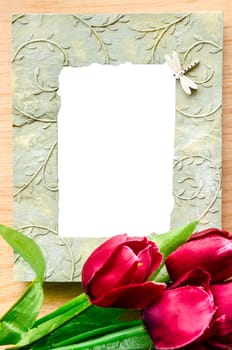 Blank ceramic photo frame and red tulip flower on wooden background, save with clipping path.