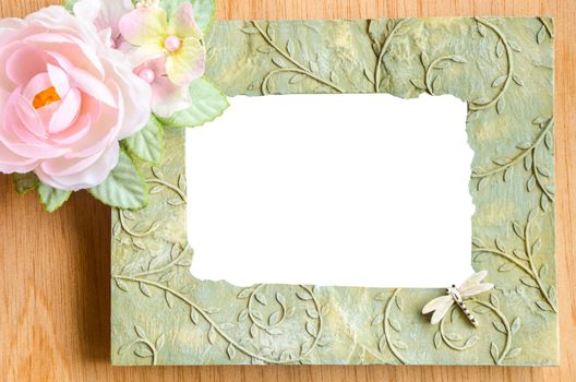 Blank photo frame and pink rose on wooden background. save clipping path.