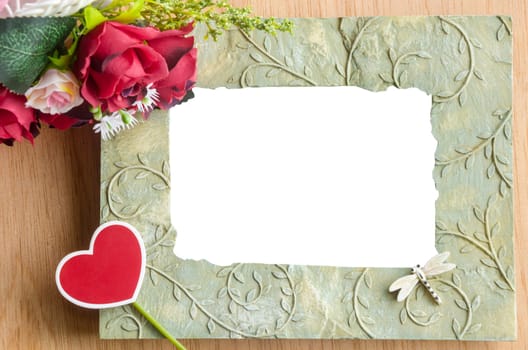 Blank photo frame and red rose wth heart shape red tag on wooden background