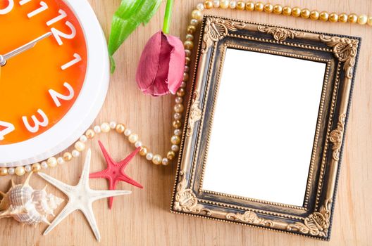 Vintage blank photo frame and clock with flower on wooden background, clipping path.