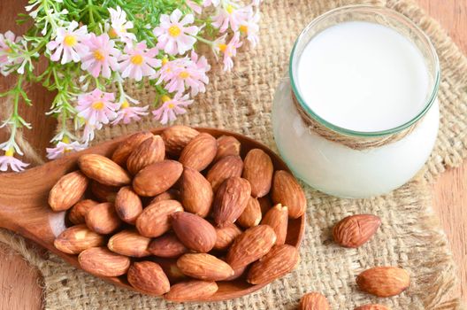 Almond milk with almond on a wooden table