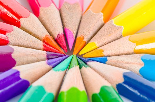 Color pencils in arrange in color wheel colors on white background