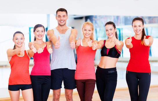 fitness, sport, training, gym and lifestyle concept - group of happy people in the gym showing thumbs up