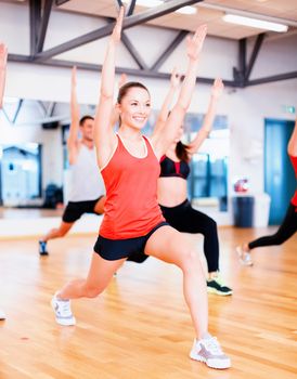 fitness, sport, training, gym and lifestyle concept - group of smiling people exercising in the gym