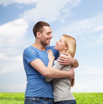 love and family concept - smiling couple hugging and looking at each other