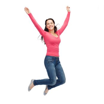 happiness, freedom, movement and people concept - smiling young woman jumping in air