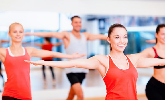 fitness, sport, training, gym and lifestyle concept - group of smiling people exercising in the gym