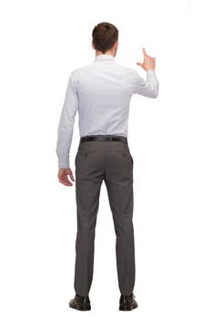 business, education and office concept - businessman or teacher pointing on something from back