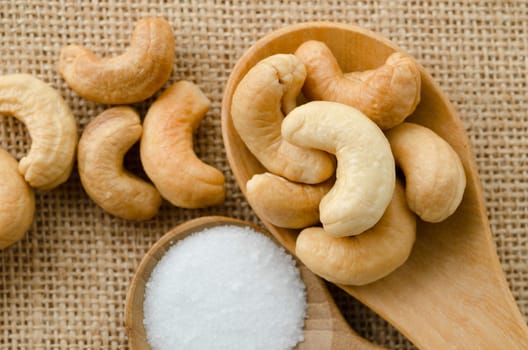 cashew nuts with salt on sack background.