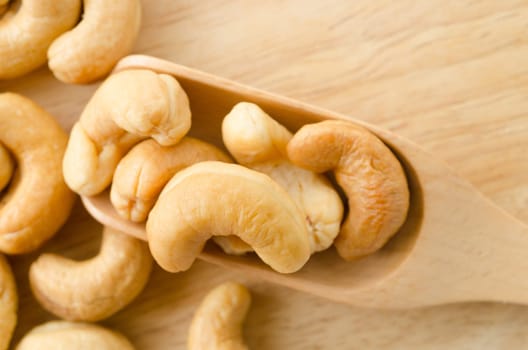 cashew nuts with salt in spoon wooden on white background.