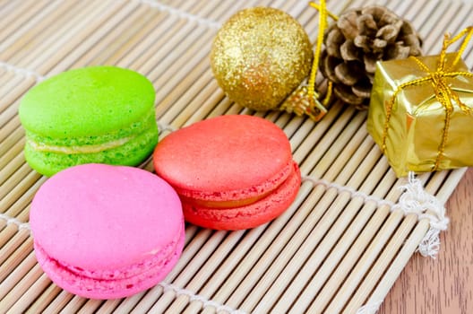 Colorful macaroons, delicious French pastries and christmas decoration on table.