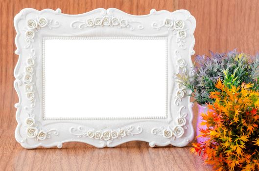 Blank Vintage Plaster white photo frame on wooden background, save clipping path.