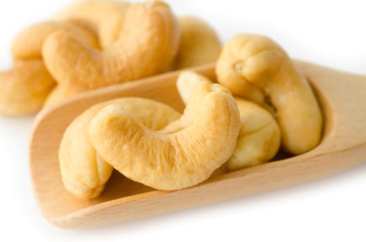 cashew nuts in wooden spoon on white background