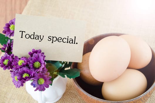 Today special and eggs in wooden bowl on woden background. Menu from eggs concept.