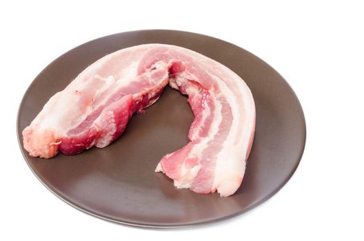 Raw bacon in brown dish on white background.