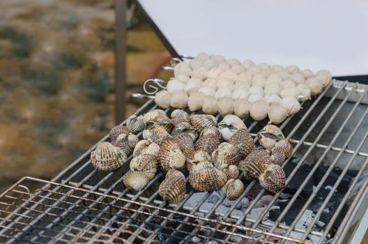 close up seafood bbq ,  cockles on flaming grill