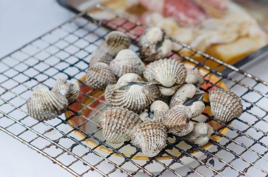 close up seafood bbq ,  cockles on flaming grill