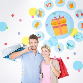 Attractive young couple holding shopping bags against dot pattern