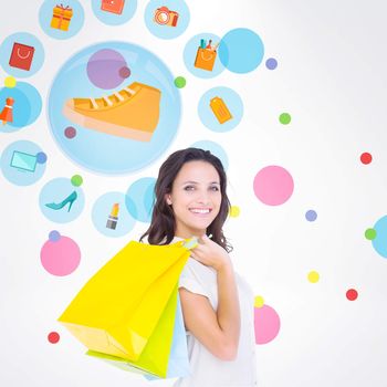 Pretty brunette with shopping bags against dot pattern