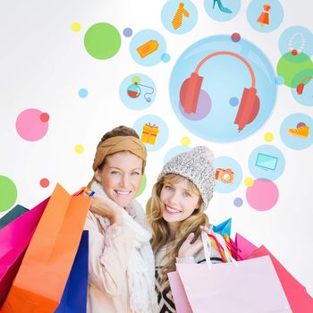 Smiling women looking at camera with shopping bags  against dot pattern