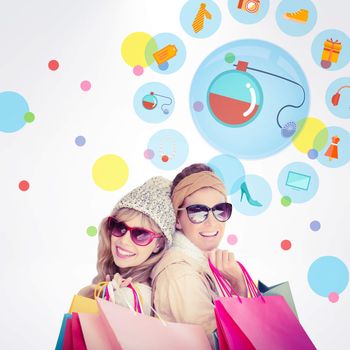 Beautiful women holding shopping bags looking at camera  against dot pattern
