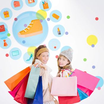 Beautiful women holding shopping bags looking at camera  against dot pattern