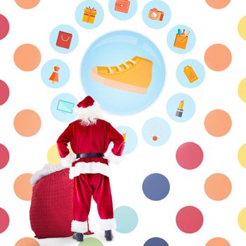 Santa with sack of gifts against colorful polka dot pattern 