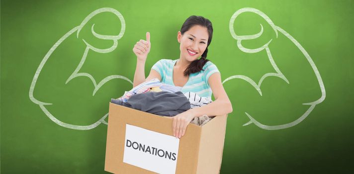 Woman with clothes donation gesturing thumbs up against green chalkboard