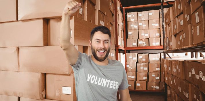 Portrait of cheerful volunteer  against shelves with boxes in warehouse